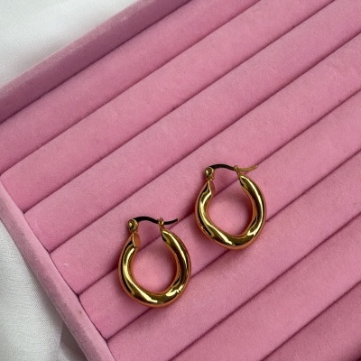 brincos de argola dourada sobre estojo rosa veludo