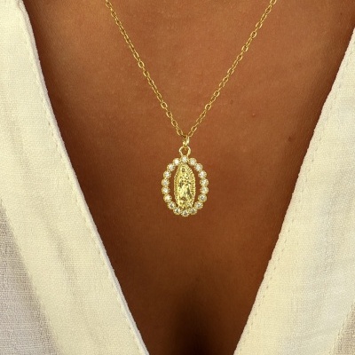 Colar dourado com pendente oval e pérolas em vestido branco