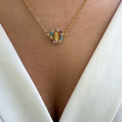 Colar dourado com pendente oval colorido numa blusa branca