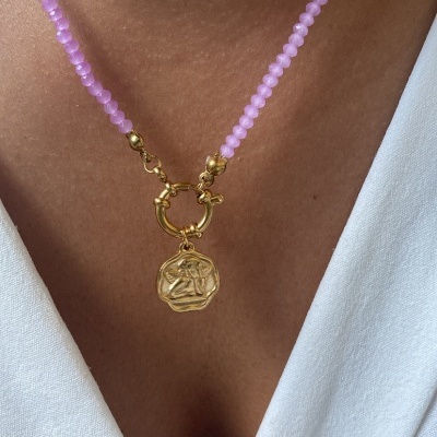 Colar com contas lilás e pendente dourado, usado com roupa branca