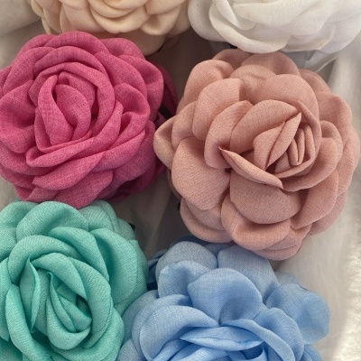 Seis flores decorativas de tecido em várias cores sobre fundo branco