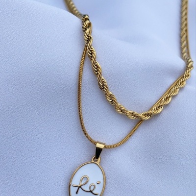 Colar dourado com pendente oval branco e assinatura dourada