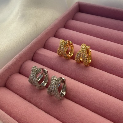 Dois pares de brincos brilhantes dourados e prateados numa caixa rosa de veludo