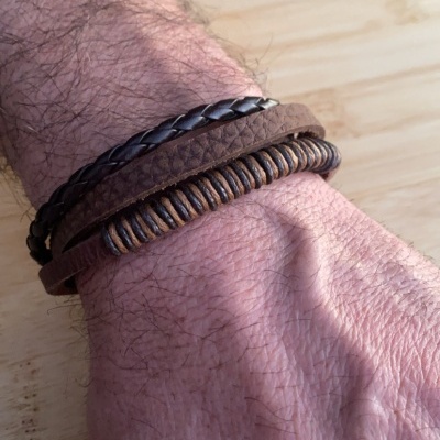Pulseira masculina em couro castanho com várias tiras usadas no pulso