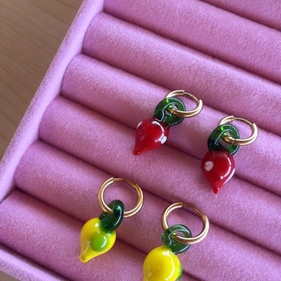 Quatro brincos com pendentes de pimento em caixa rosa aveludada