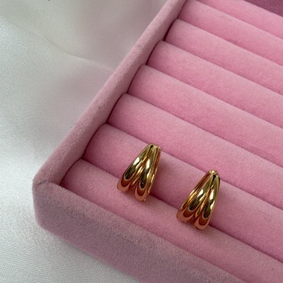 Brincos dourados em caixa de veludo rosa