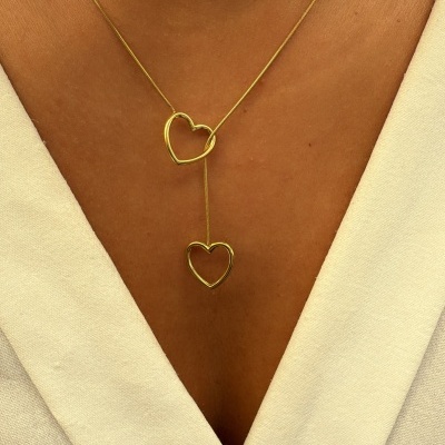 Colar dourado com corações em pescoço com vestido branco