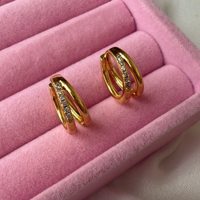 Brincos dourados com pedras em caixa de veludo rosa