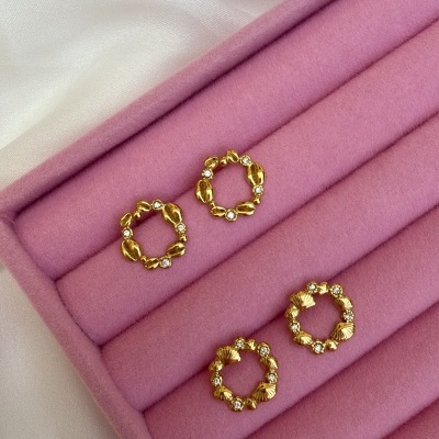 Dois pares de brincos dourados com detalhes em pedras brilhantes em caixa de veludo rosa