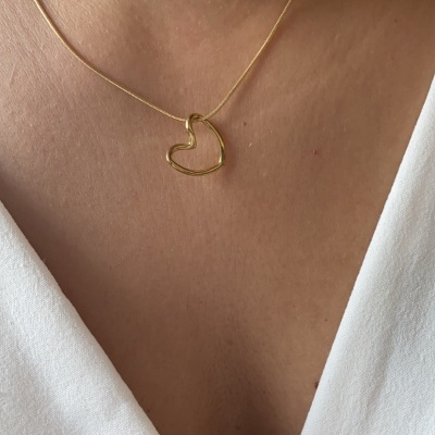 Colar dourado com coração abstrato e blusa branca