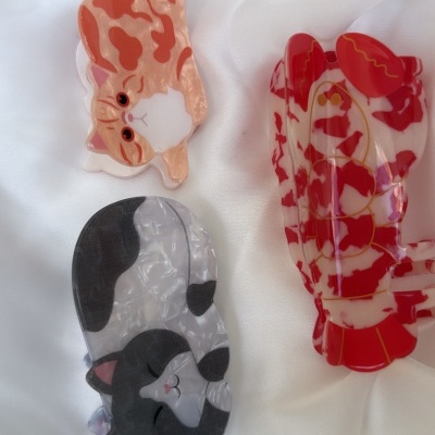 Ganchos de cabelo de acrílico com padrões de gatos e cores vermelha, cinza e branco em fundo branco