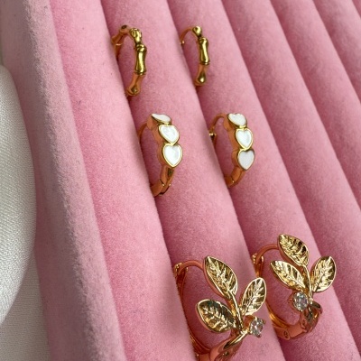 Três pares de brincos dourados numa caixa de veludo rosa