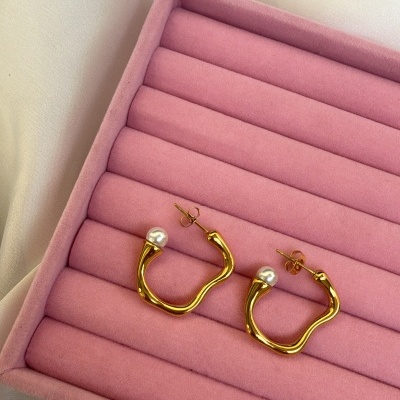 Brincos de argola dourados com pérola numa caixa rosa