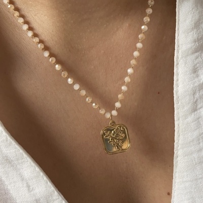 Colar de contas brancas com pendente dourado em relevo