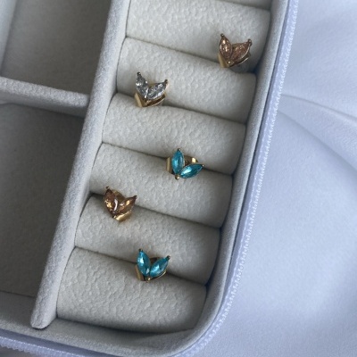 Conjunto de cinco anéis dourados com pedras coloridas em caixa branca aveludada