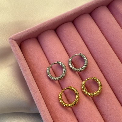Dois pares de brincos de aro prateado e dourado em caixa rosa