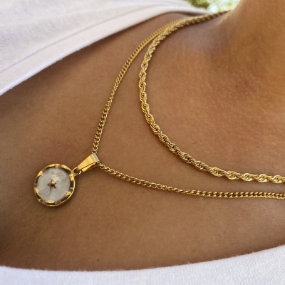 Colar dourado com pendente redondo branco e detalhe de estrela no centro