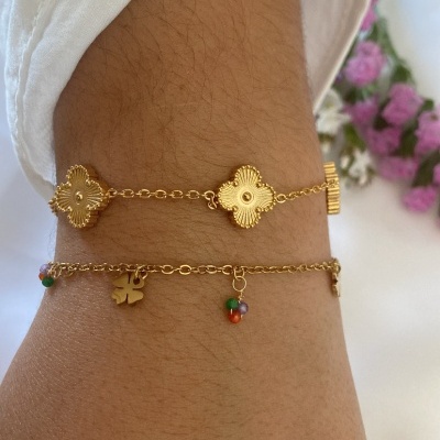 Duas pulseiras douradas delicadas num pulso com manga branca