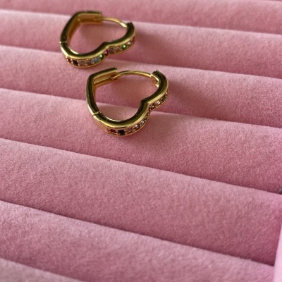 Brincos de argola dourados com pedras coloridas em suporte rosa