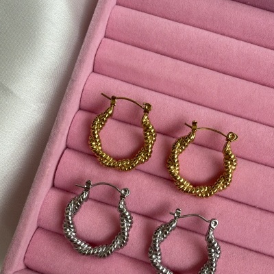 Dois pares de brincos argola textura torcida dourado e prateado em caixa rosa