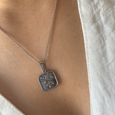 Colar prateado com pendente quadrado com rosa em relevo