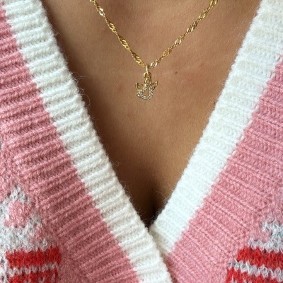 Colar dourado com pendente de anjo e camisola rosa com padrão e gola branca