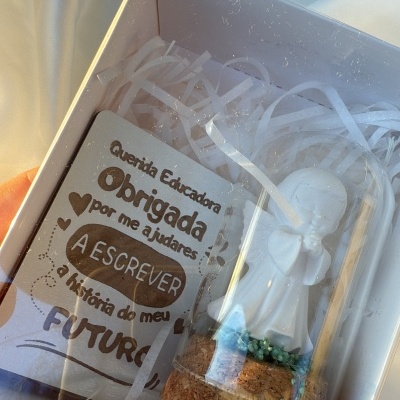 Caixa com figura branca e cartão com texto de agradecimento à educadora