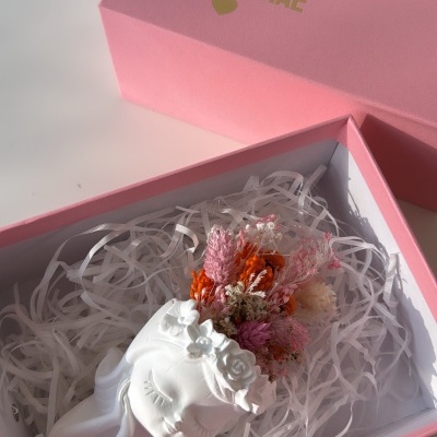 Caixa rosa com texto AMO-TE MÃE dourado e escultura branca com flores secas coloridas dentro