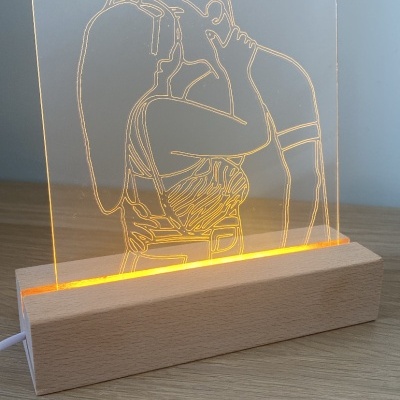 Luminária decorativa com desenho de casal a beijar-se iluminado