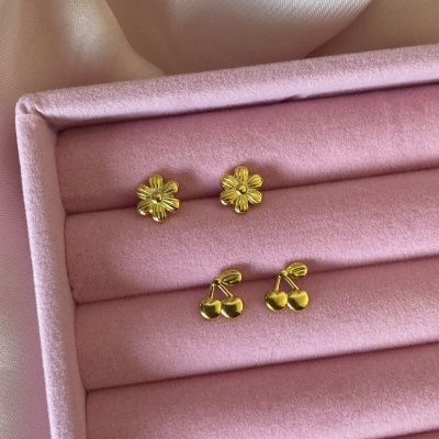 Dois pares de brincos dourados em caixa rosa com fundo de tecido cetim