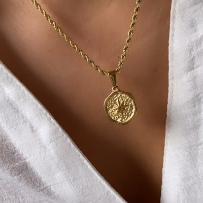 Colar dourado com pendente de estrela e camisa branca