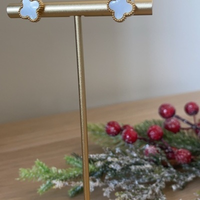 Brincos em forma de trevo branco com contorno dourado em suporte dourado