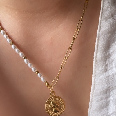 Colar com metade de pérolas e metade de elos dourados e pendente redondo dourado no pescoço