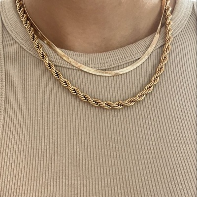 Colares dourados femininos usados sobre camisola bege canelada