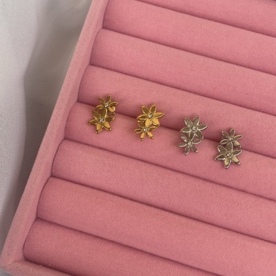 Brincos pequenos em forma de flor dourados e prateados em estojo almofadado rosa