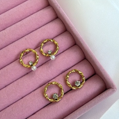 Dois pares de brincos dourados em caixa rosa de veludo