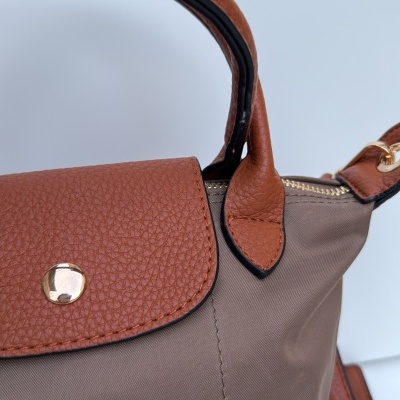 Mala de mão em tecido castanho com detalhes em pele castanha e fecho dourado