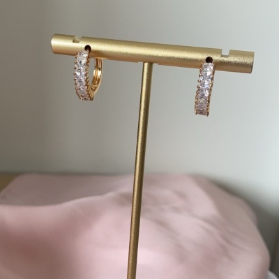 Brincos de argola dourados com pedras numa base dourada hexagonal