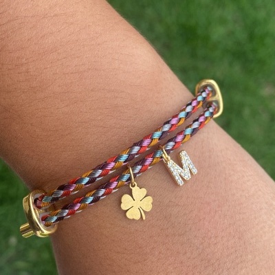 Pulseira trançada colorida com pendentes dourados e brilhantes