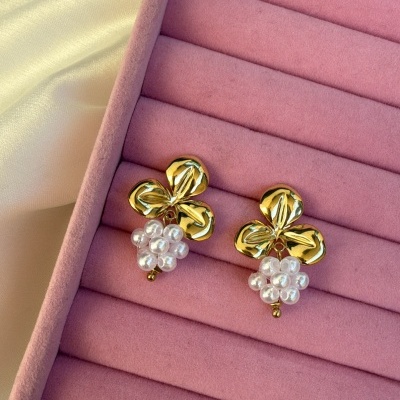 Brincos dourados com pendentes de pérolas em caixa de veludo rosa