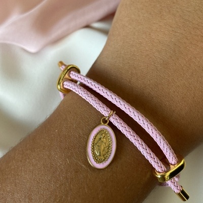 Pulseira rosa com pendente dourado em pulso