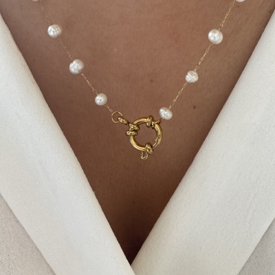 Colar com pérolas brancas e corrente dourada, usado com roupa branca