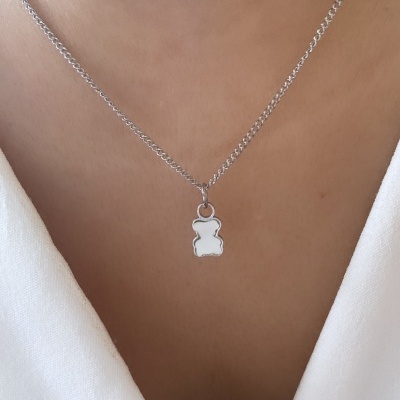 Colar de corrente prateada com pendente de ursinho prateado ao pescoço
