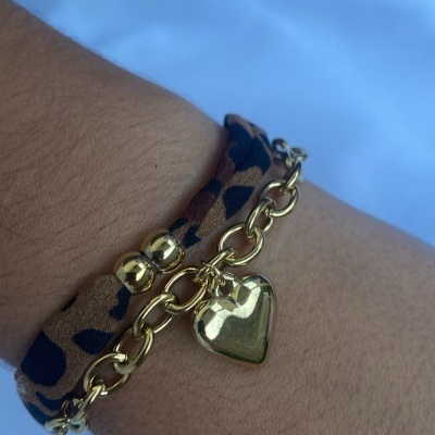 Pulseira dupla dourada com pendente de coração e fita animal print no pulso