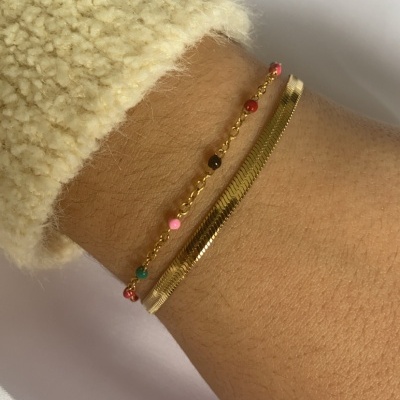 Pulso com duas pulseiras douradas e suéter de malha bege