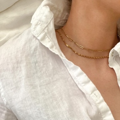 Colar dourado em dois fios e camisa branca de linho com gola aberta