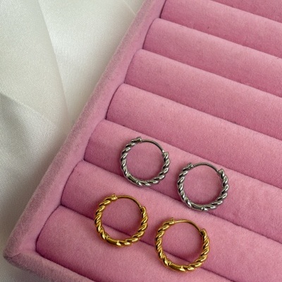Par de brincos de argola dourados e prateados em caixa de veludo rosa