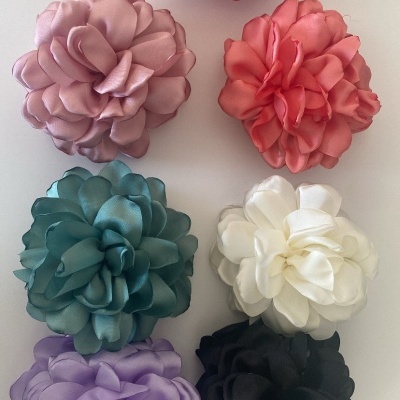 Flores artificiais de tecido coloridas em superfície branca