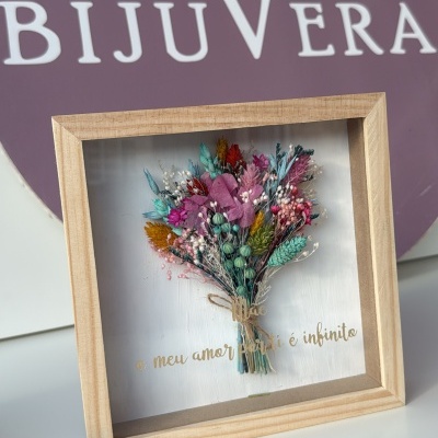 Quadro decorativo com flores secas coloridas e texto em português