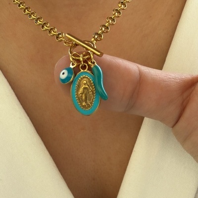 Colar dourado com pendentes azul e dourado usado em pessoa com roupa bege